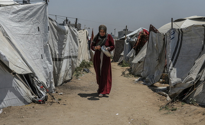 Displaced Palestinians collect donated food in Jabalia, northern Gaza